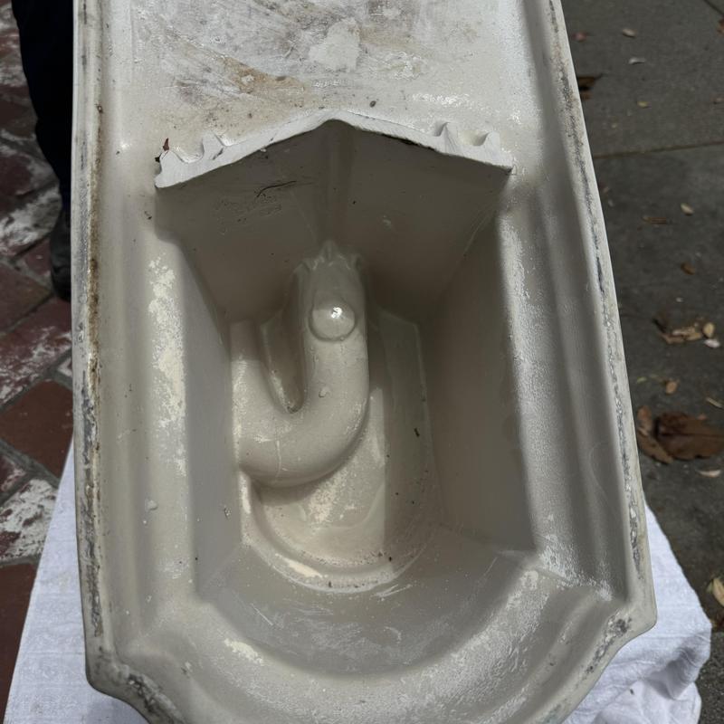 Toilet base with broken trapway inside bowl