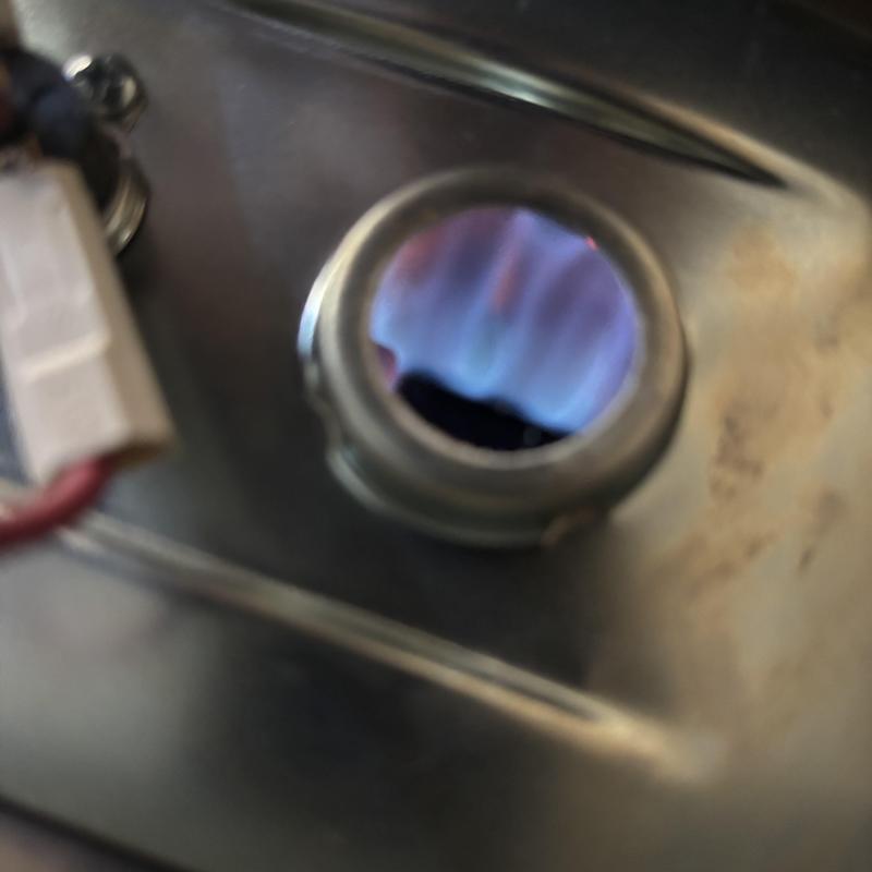 Water heater pilot flame ignition inside metal chamber