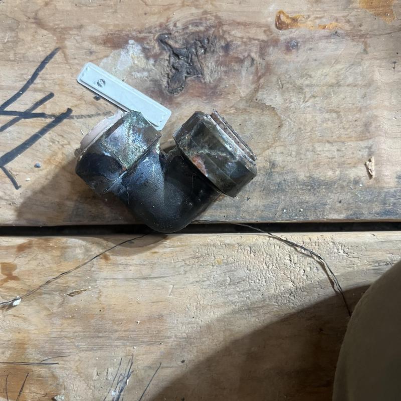 Yard water line elbow fitting on wooden surface