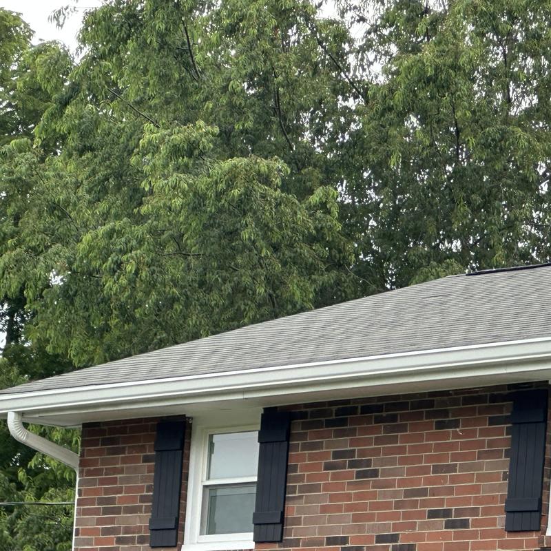 Roof shingles on residential brick house with gutters Roof shingles on residential brick house with gutters