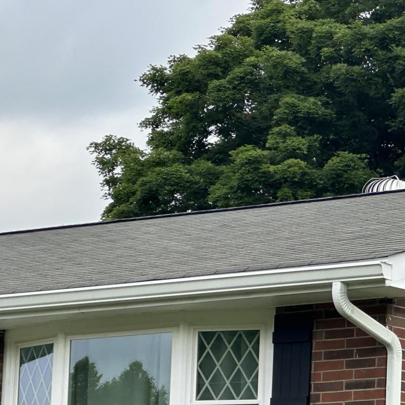 Asphalt shingle roof on residential home, cloudy sky Asphalt shingle roof on residential home, cloudy sky