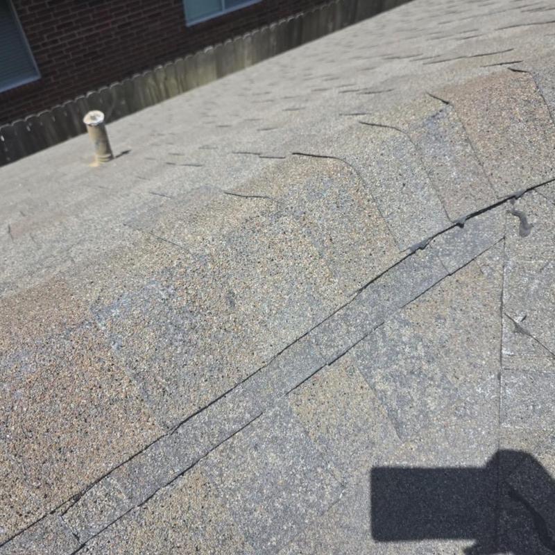 Architectural shingles hail damage on roof ridge