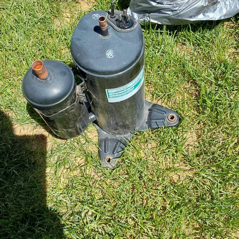 Goodman GSX13 air conditioner compressor on grass