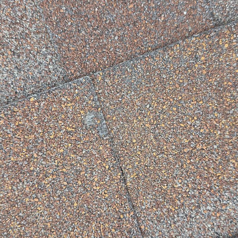 Asphalt roof shingles with hail damage close-up