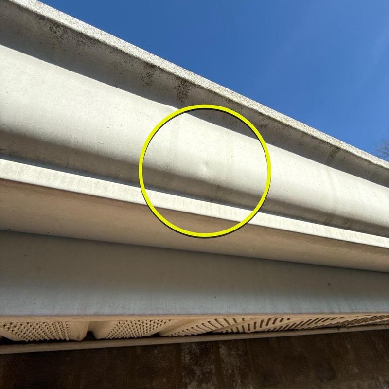 Gutter with hail damage dent circled in yellow