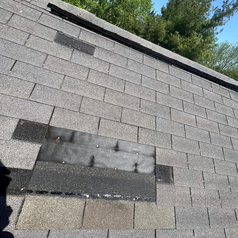 Asphalt shingle roof section with repair patch and nails