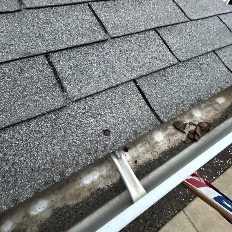 Shingles and gutter showing hail and wear damage