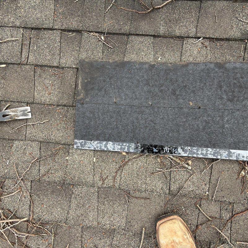 Roof shingles with hail damage and pry bar on roof