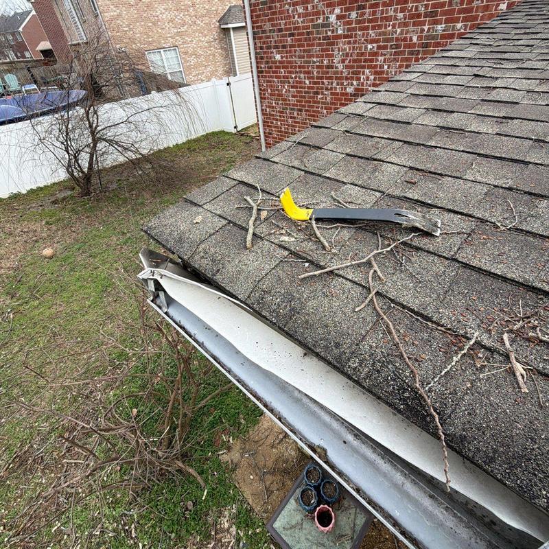 Asphalt shingles with hail and debris damage on roof edge