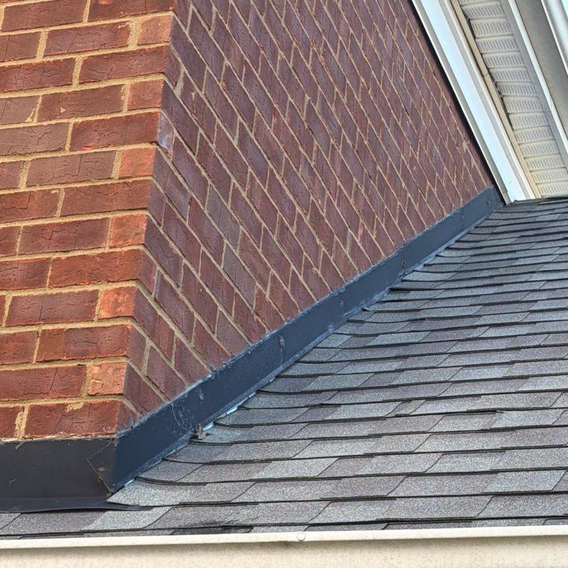 Roof shingles and brick chimney flashing installation detail