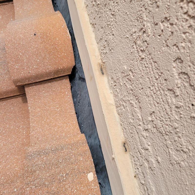 Concrete tile roof edge with flashing and stucco wall Concrete tile roof edge with flashing and stucco wall