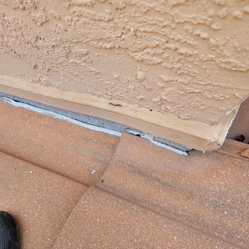 Concrete tile roof flashing with sealant at wall base Concrete tile roof flashing with sealant at wall base