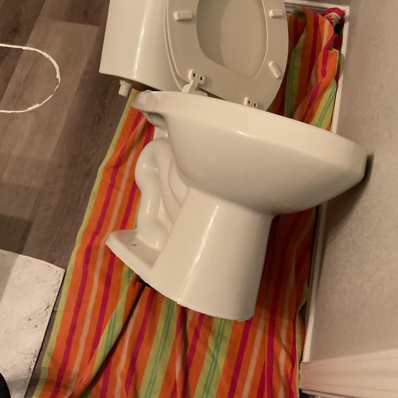 Toilet installation on striped protective covering Toilet installation on striped protective covering