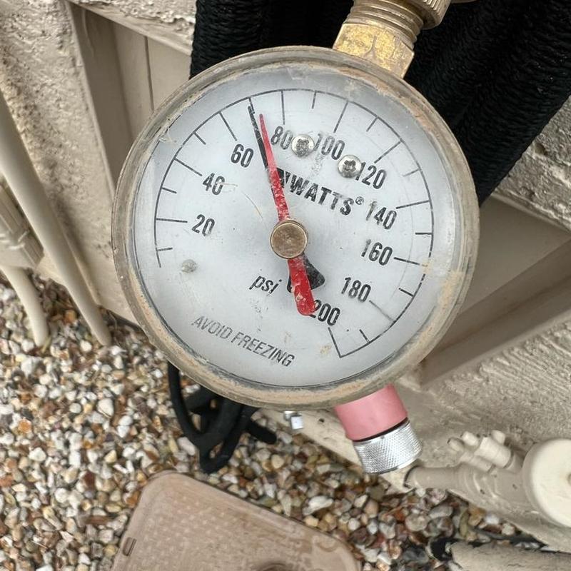 Water pressure gauge reading 68 PSI outdoors