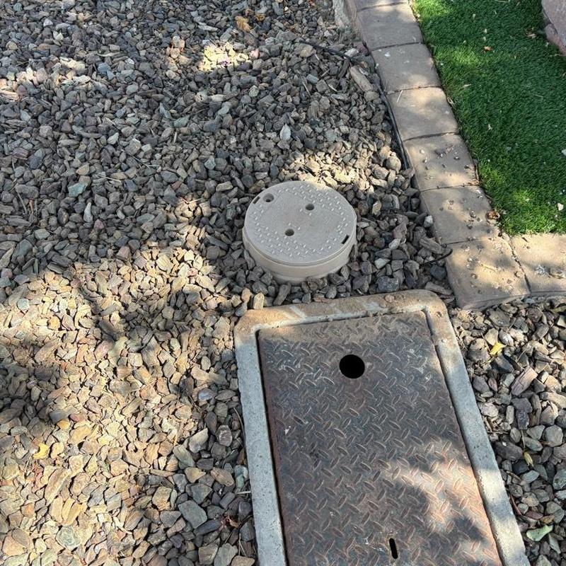 Pressure relief valve and tan access box near water meter