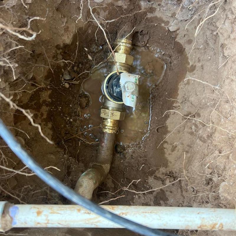 Pressure-reducing valve on main water line in soil hole