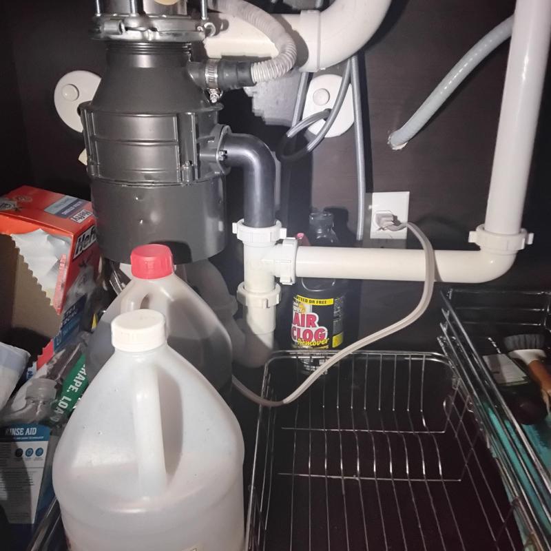 Garbage disposal and drain pipes under kitchen sink
