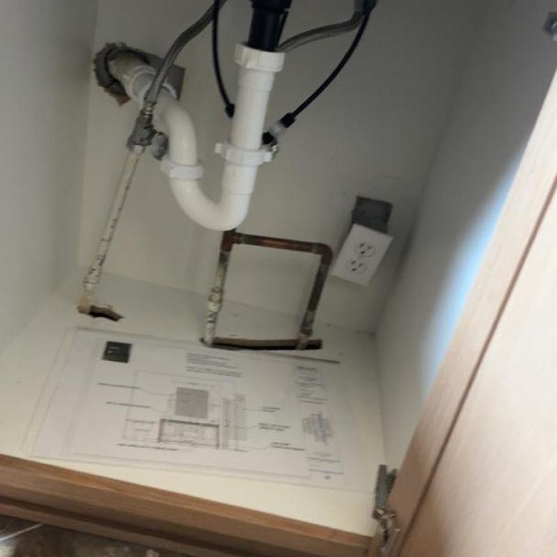 PVC drain pipe and copper water lines under sink cabinet