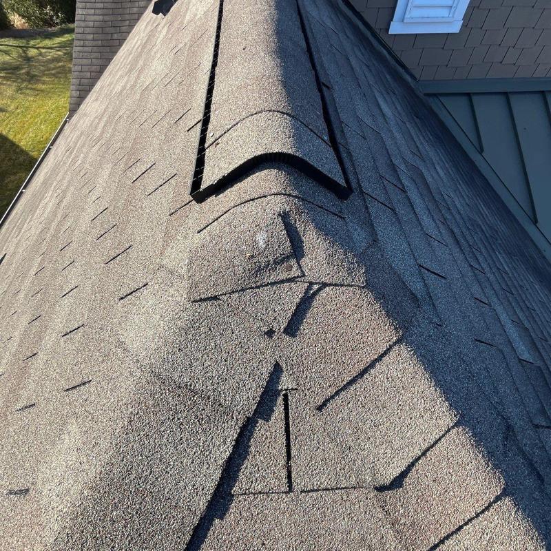 Roof shingles with hail impact and lifted ridge cap