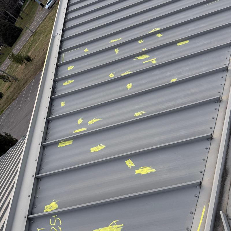Metal roofing panels with marked hail damage spots