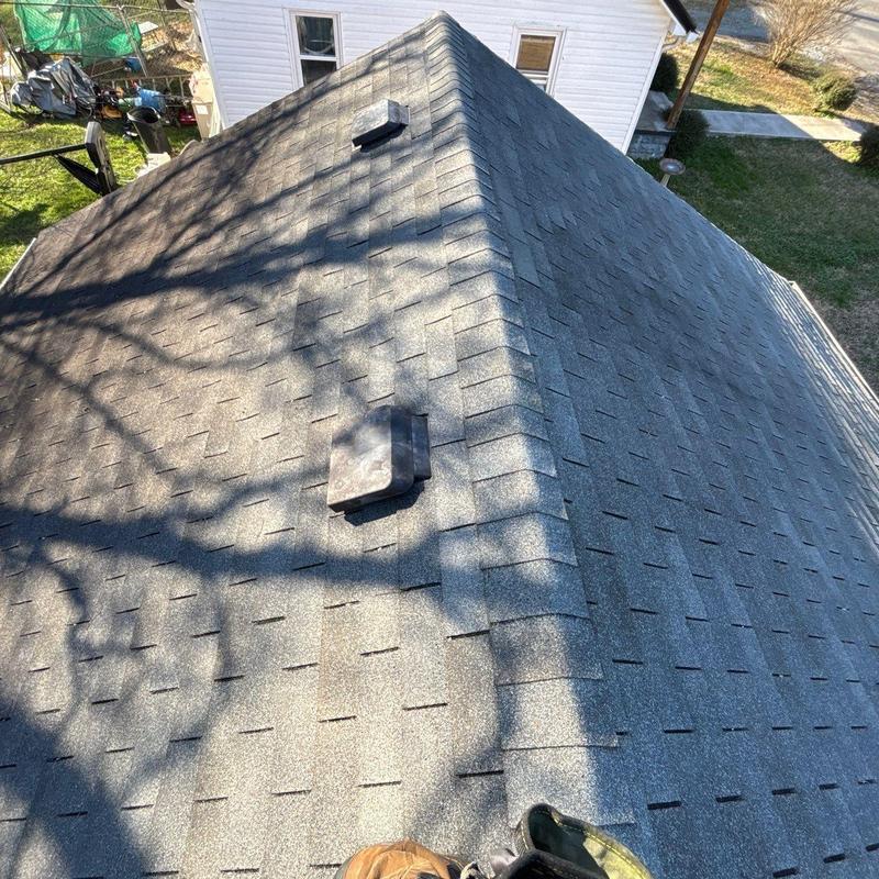 Asphalt shingle roof with ventilation vents and hail damage