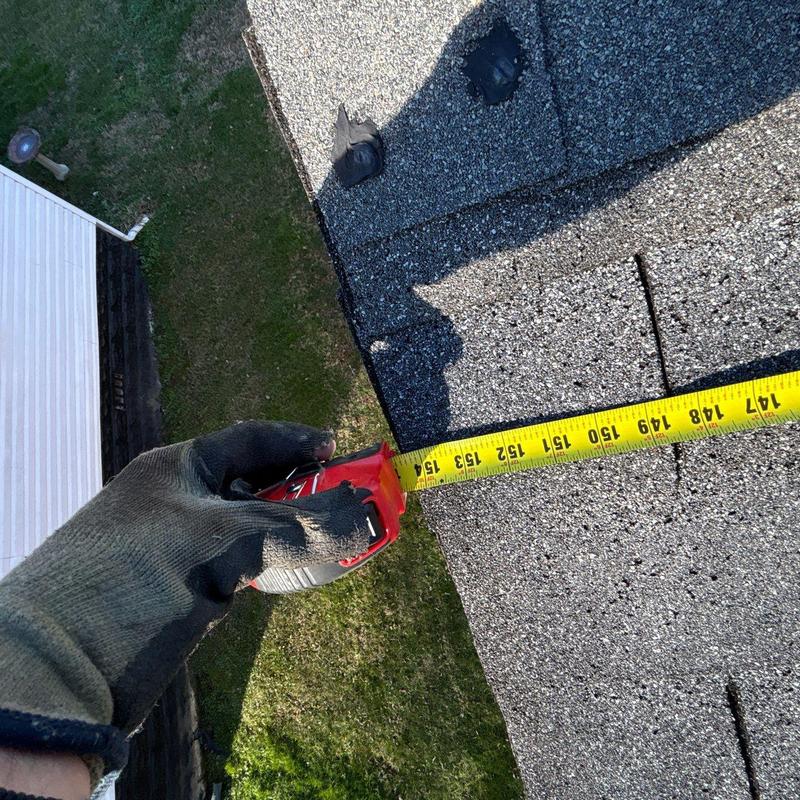 Shingles measuring with tape for hail damage inspection