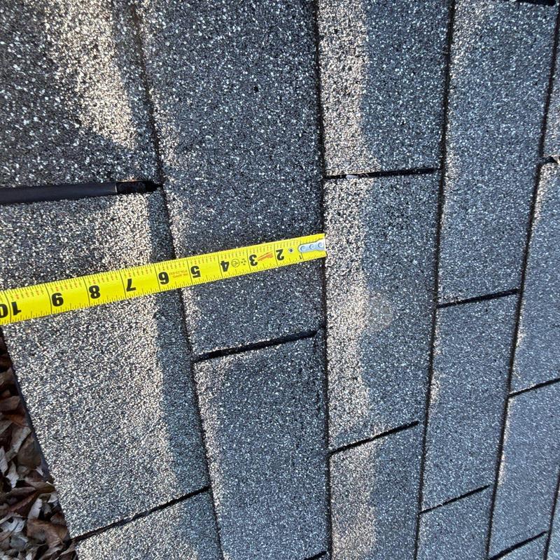 Asphalt roof shingles with measuring tape
