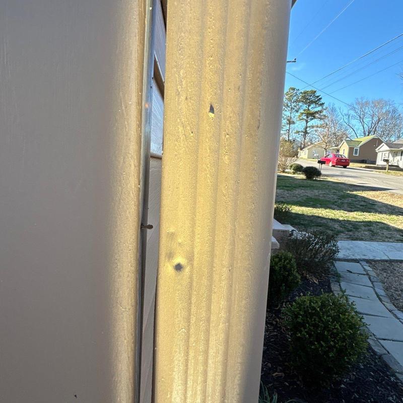 Metal downspout with hail damage dents outdoors