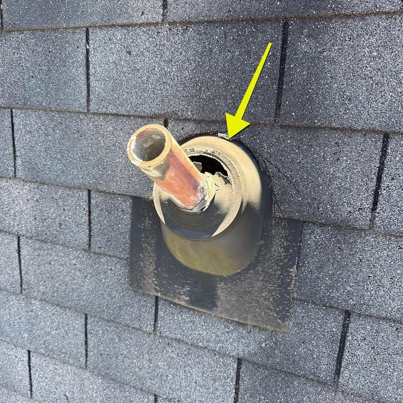 Roof pipe flashing with hail damage hole on shingles