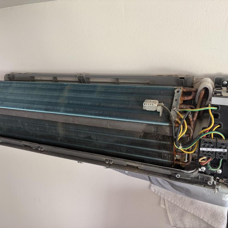 AC evaporator coil and wiring exposed for inspection