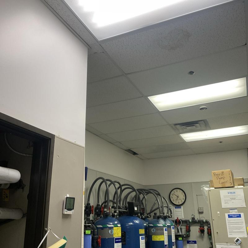 Water filtration system with multiple blue tanks in utility room