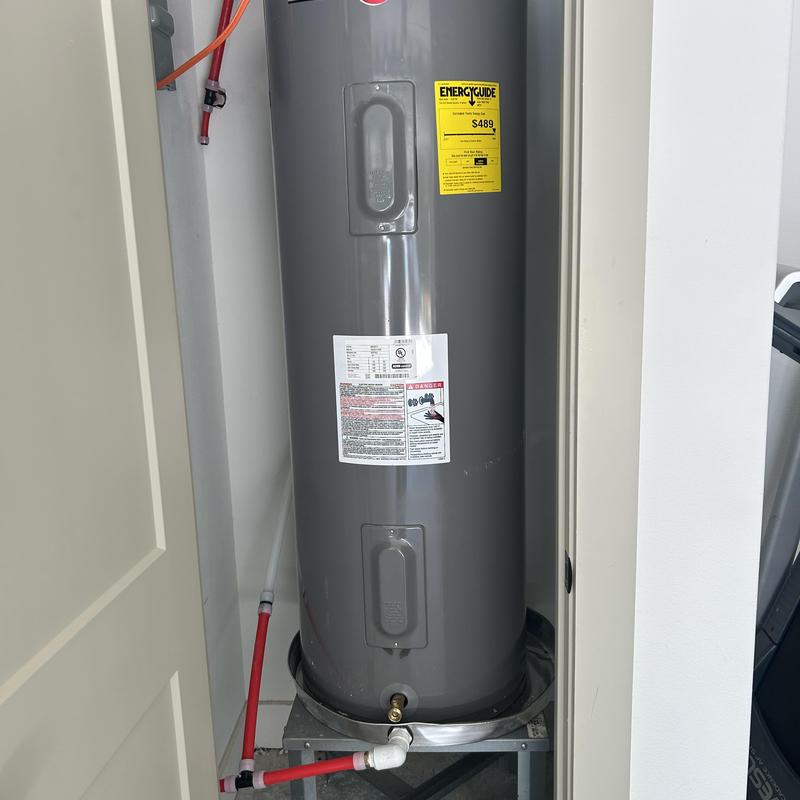 Water heater on raised platform with drain pan
