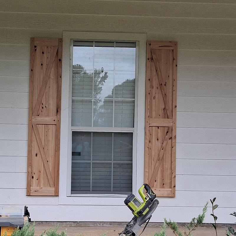 Custom wooden window shutters installation on porch Custom wooden window shutters installation on porch