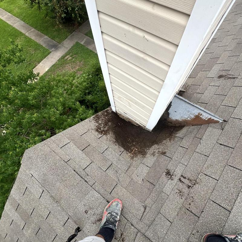 Chimney base with roof shingle debris and damage