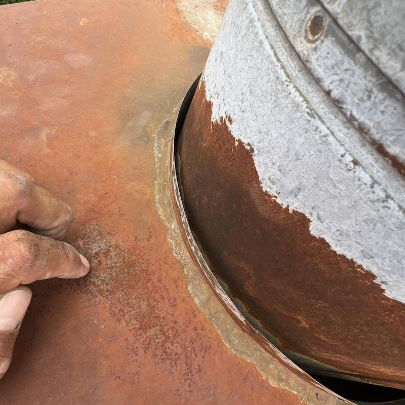 Chimney base metal flashing with rust and gap defect