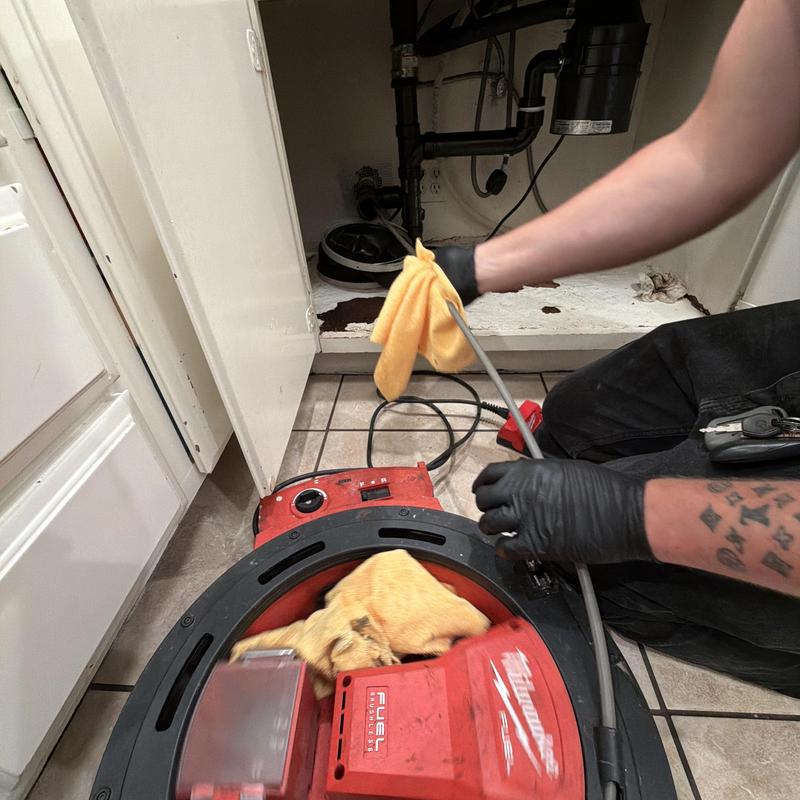 Kitchen drain line with descale tool and plumber working Kitchen drain line with descale tool and plumber working