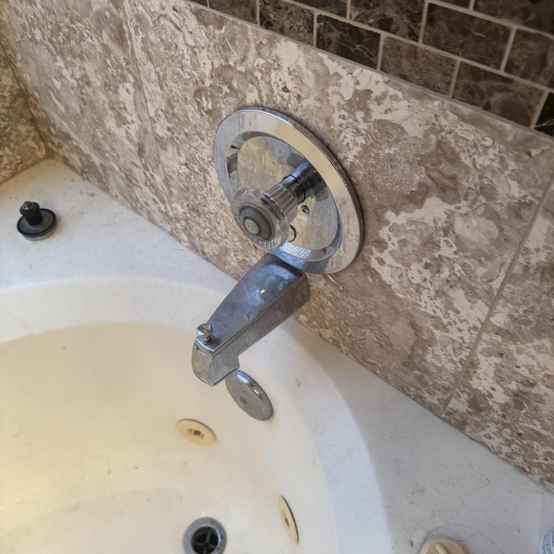 Shower faucet and handle with tiled wall background