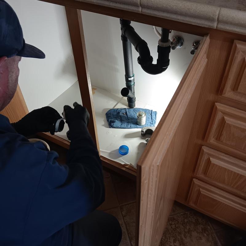 Drain line plumbing under kitchen sink with pipe fittings