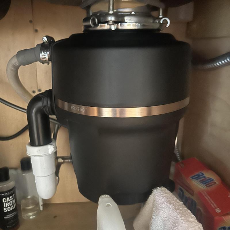 Garbage disposal unit under kitchen sink with plumbing