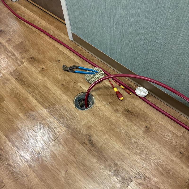 Drain pipe hydro-jetting with tools on wood floor Drain pipe hydro-jetting with tools on wood floor
