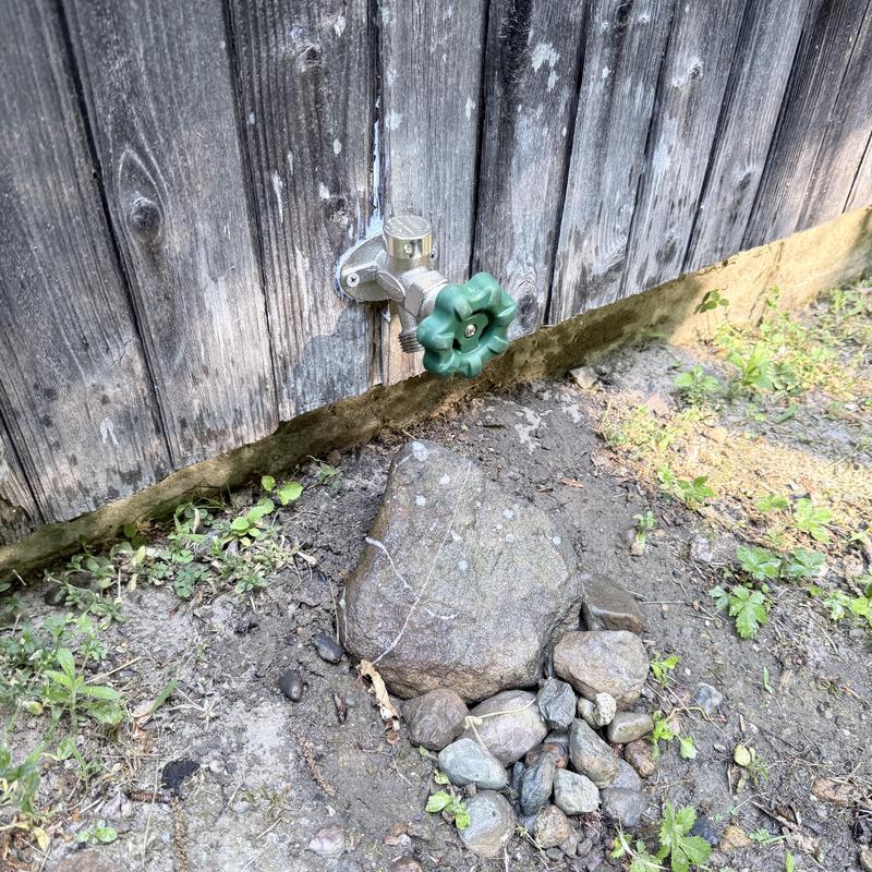 Silcock with green handle mounted on wooden wall outdoors Silcock with green handle mounted on wooden wall outdoors
