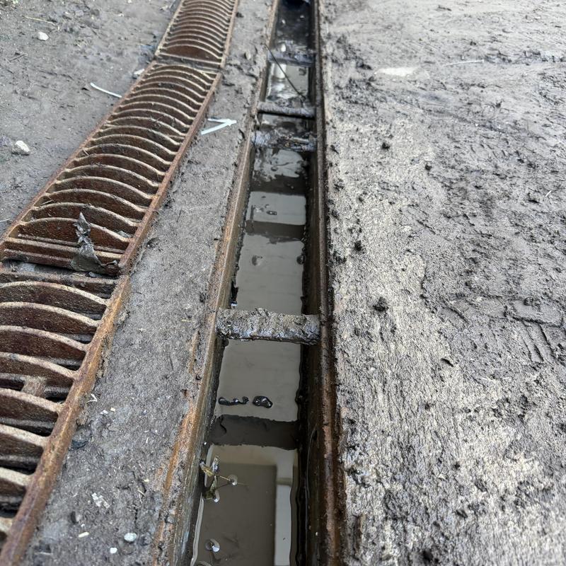 Loading dock drain with rusted metal grate and mud Loading dock drain with rusted metal grate and mud