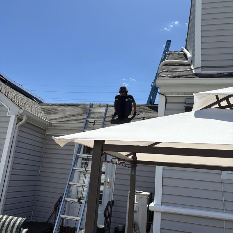 Roof gutter jet cleaning with worker on ladder in Fairfield NJ Roof gutter jet cleaning with worker on ladder in Fairfield NJ