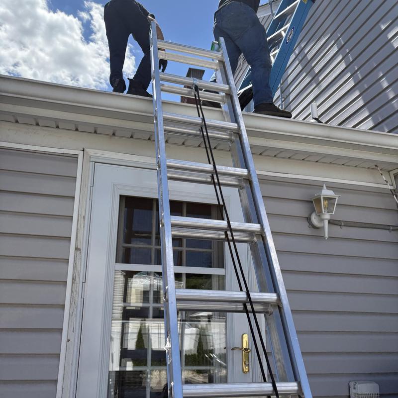 Roof gutter jet cleaning with ladder and workers Roof gutter jet cleaning with ladder and workers