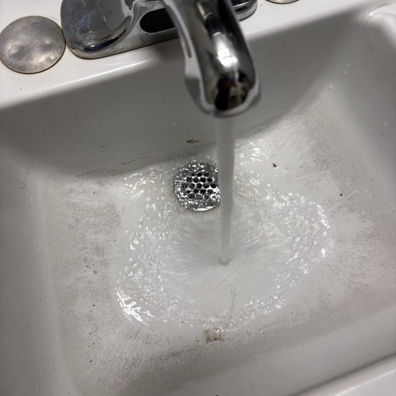 Chrome sink P-trap with water flow clearing blockage Chrome sink P-trap with water flow clearing blockage
