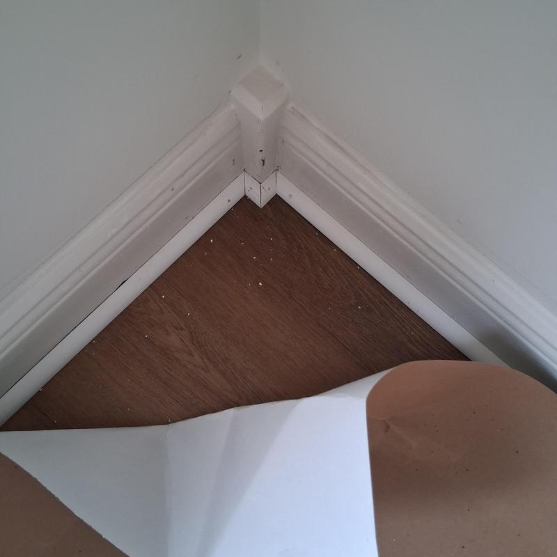 Quarter round molding installation on wood flooring corner