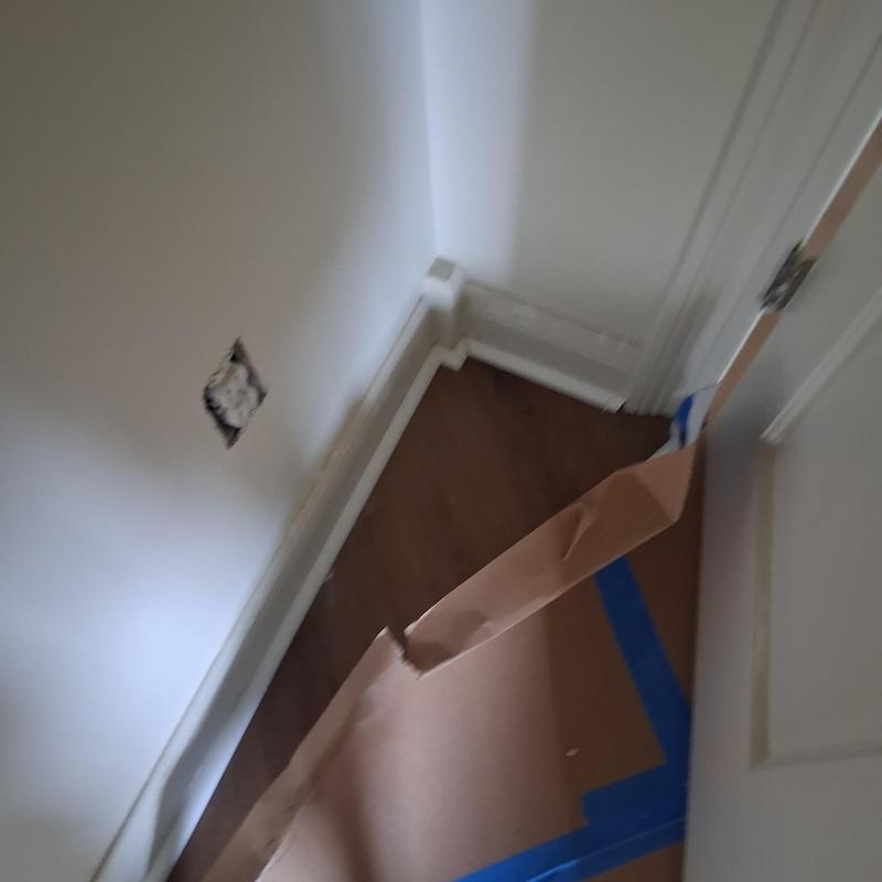 Quarter round molding installation on wood flooring corner