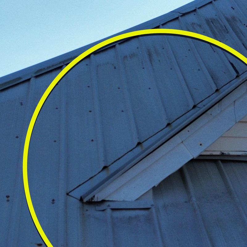 Metal roof panel hail damage inspection close-up