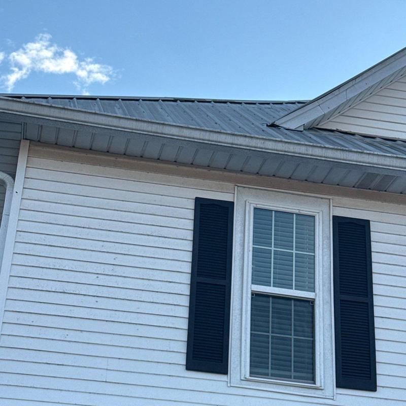 Metal roof with visible hail damage near window
