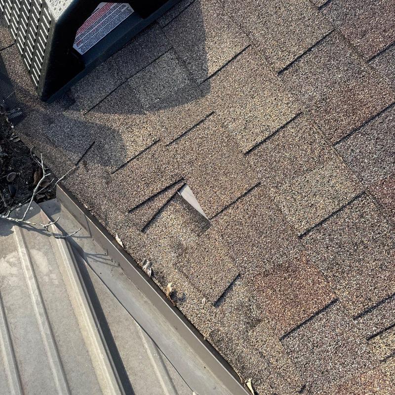 Asphalt shingles with hail damage and roof vent nearby